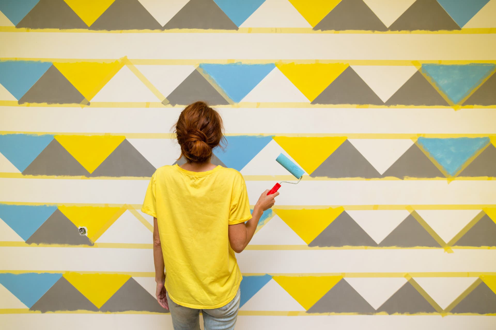 interior,design.,the,girl,paints,the,wall,in,geometric,pattern.