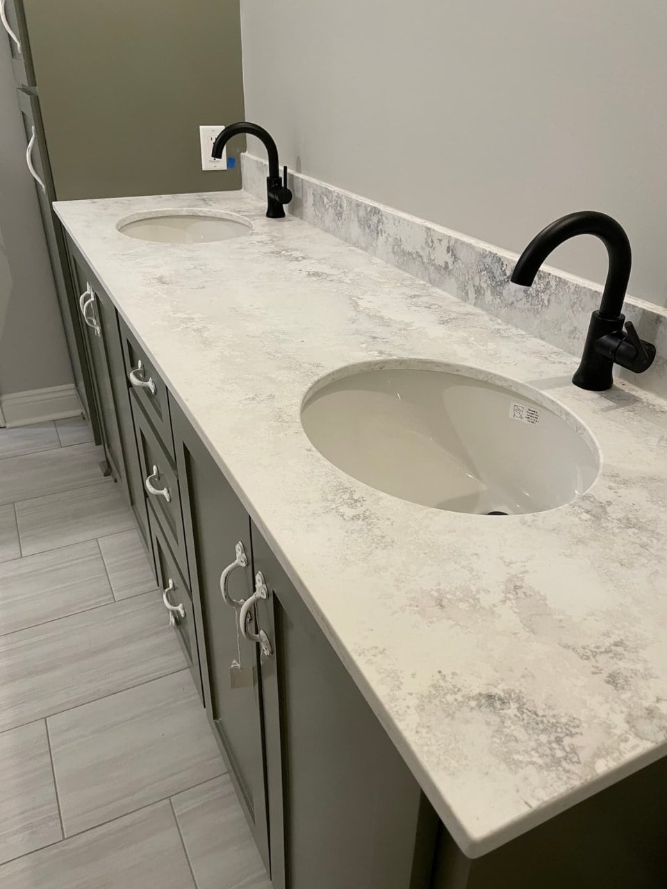 a bathroom with two sinks and marble counter tops.