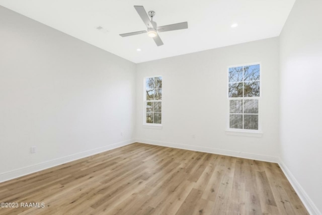 an empty room with wood floors and a ceiling fan.