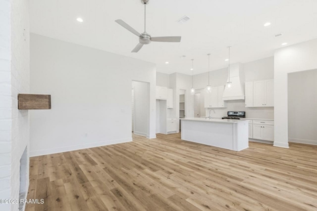 an empty kitchen with hardwood floors and a ceiling fan.