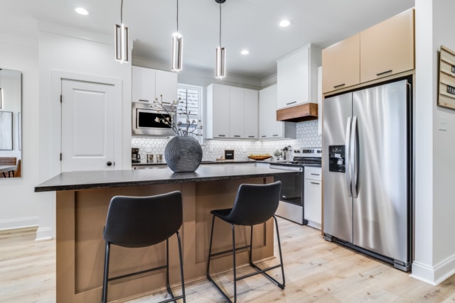 a kitchen with stainless steel appliances and a bar stools.