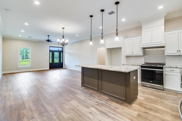 an empty kitchen with hardwood floors and a ceiling fan.