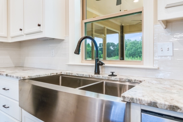 a kitchen with a stainless steel sink and window.