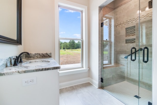 a bathroom with a glass shower door and sink.