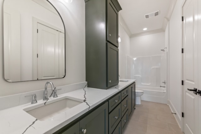 a bathroom with green cabinets and a mirror.