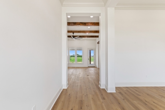 an empty room with white walls and hardwood floors.