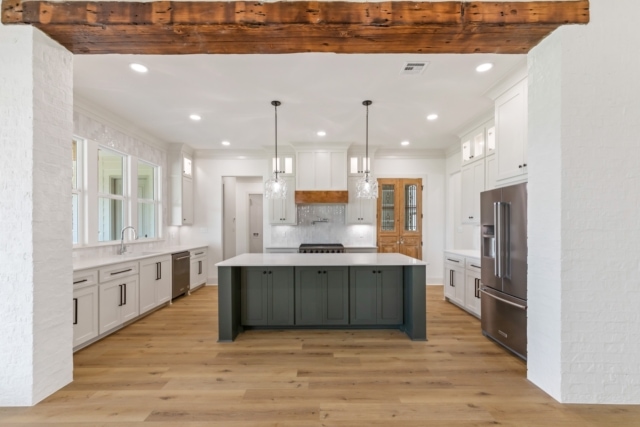 a kitchen with wood beams and white cabinets.