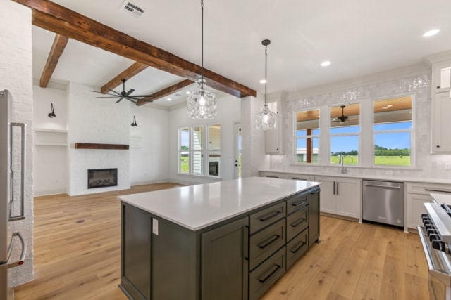 a kitchen with hardwood floors and wood beams.