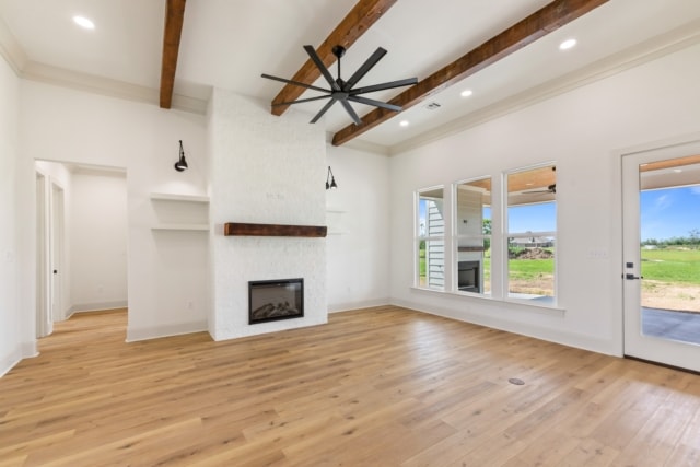 an empty living room with wood beams and a fireplace.