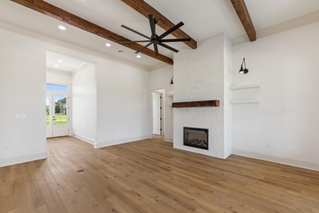 an empty living room with wood floors and a fireplace.