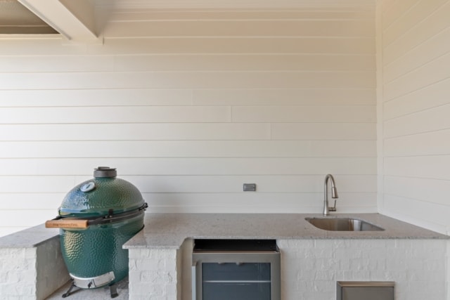 an outdoor kitchen with a sink and a green egg.