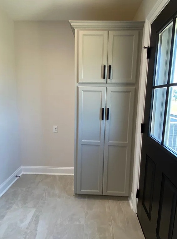 an empty room with a gray cabinet and door.