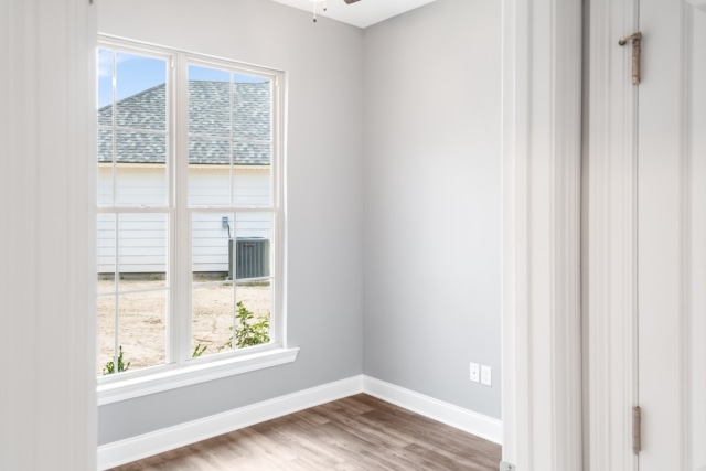 an empty room with hardwood floors and a window.