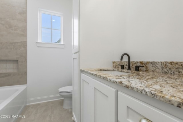 a bathroom with granite counter tops and white cabinets.