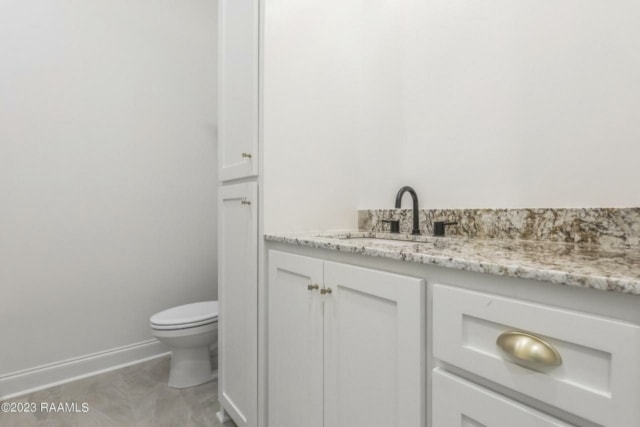 a bathroom with white cabinets and granite counter tops.