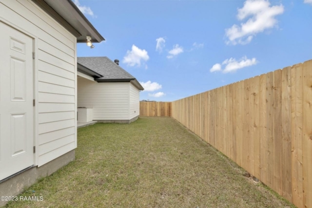 a backyard with a wooden fence and a white fence.