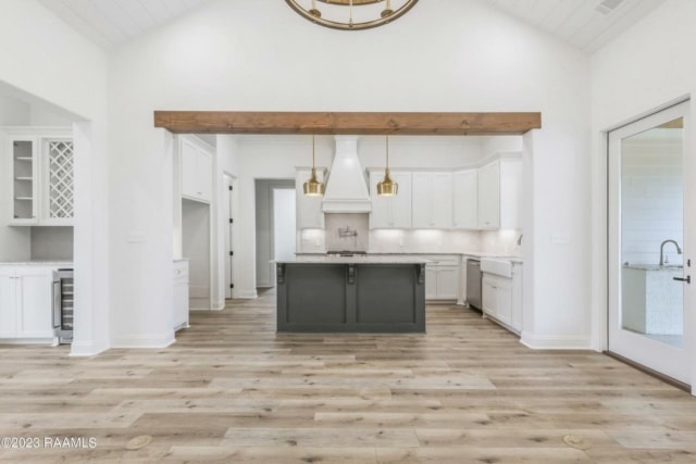 a white kitchen with wood floors and a wooden ceiling.