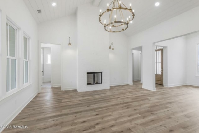 a white living room with hardwood floors and a chandelier.