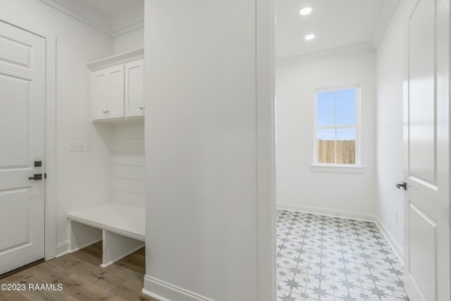 a white hallway with a tiled floor and white cabinets.