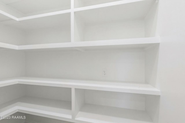 a white closet with white shelves in it.