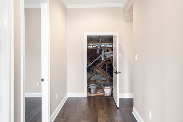 a hallway with wood floors and a door.
