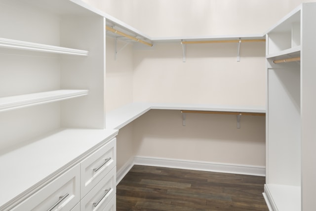 a white walk in closet with shelves and drawers.