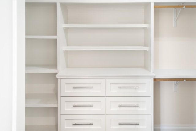 a white closet with drawers and shelves.