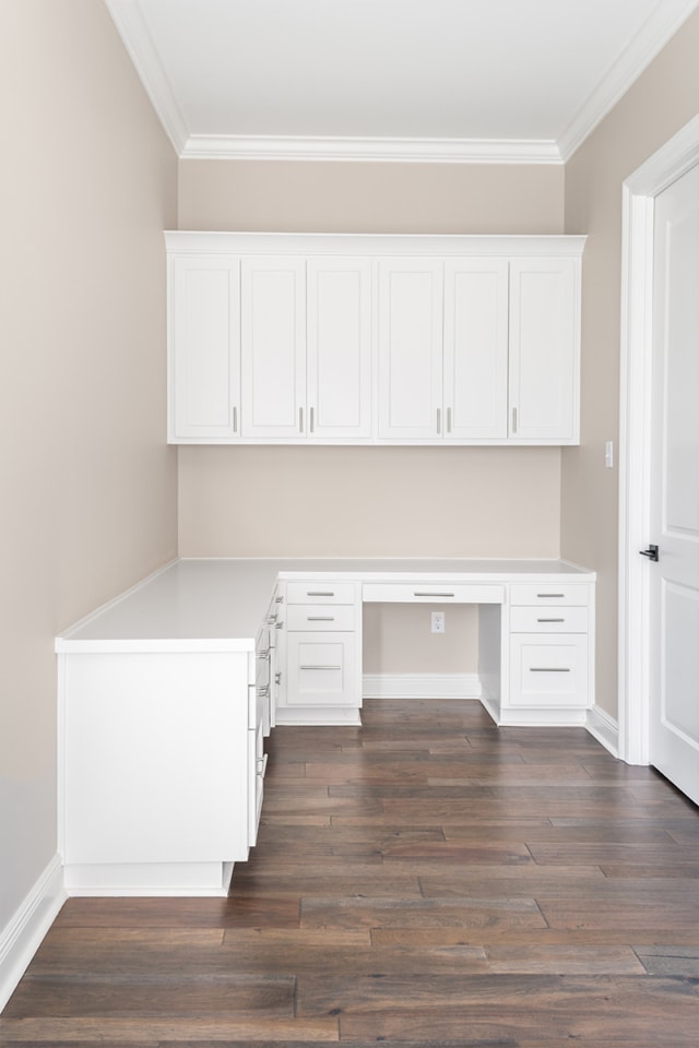 a room with white cabinets and hardwood floors.