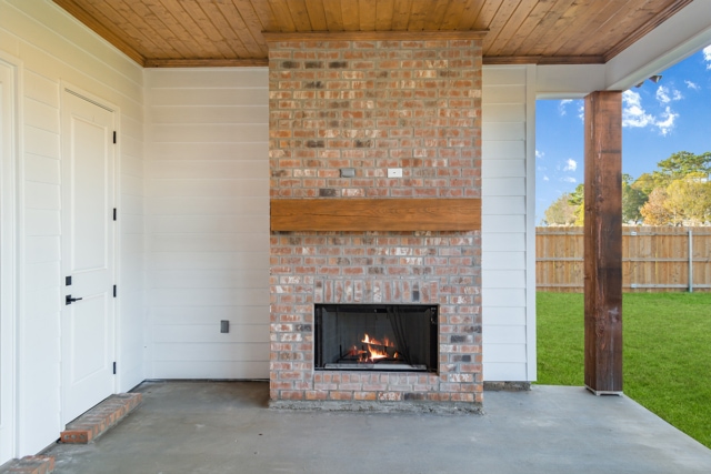 a brick fireplace in a backyard.