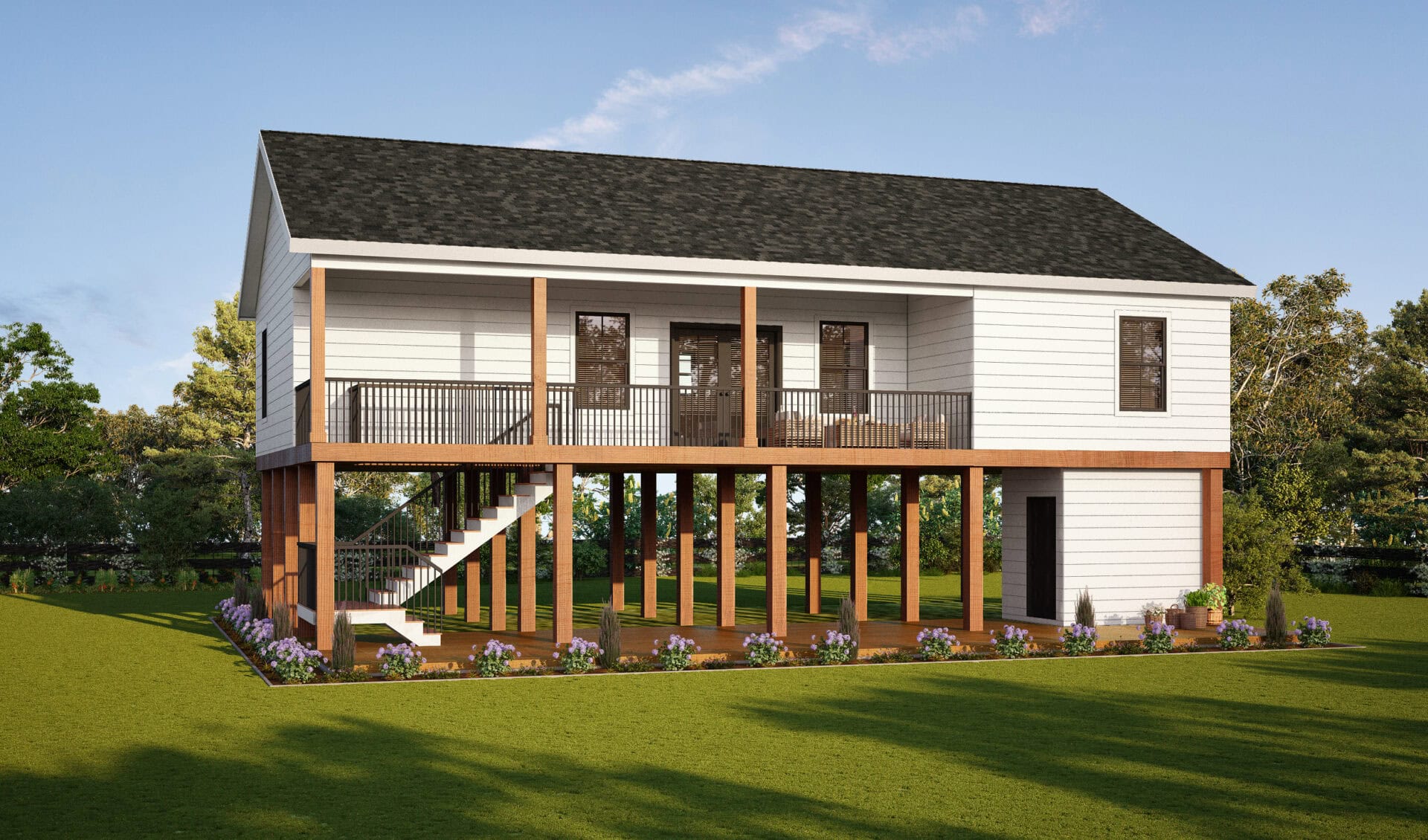 A white elevated house with a black roof sits on tall wooden stilts, featuring a wide front porch with railing, stairs leading up, and landscaped flower beds around the base. Lawn and trees surround the structure.