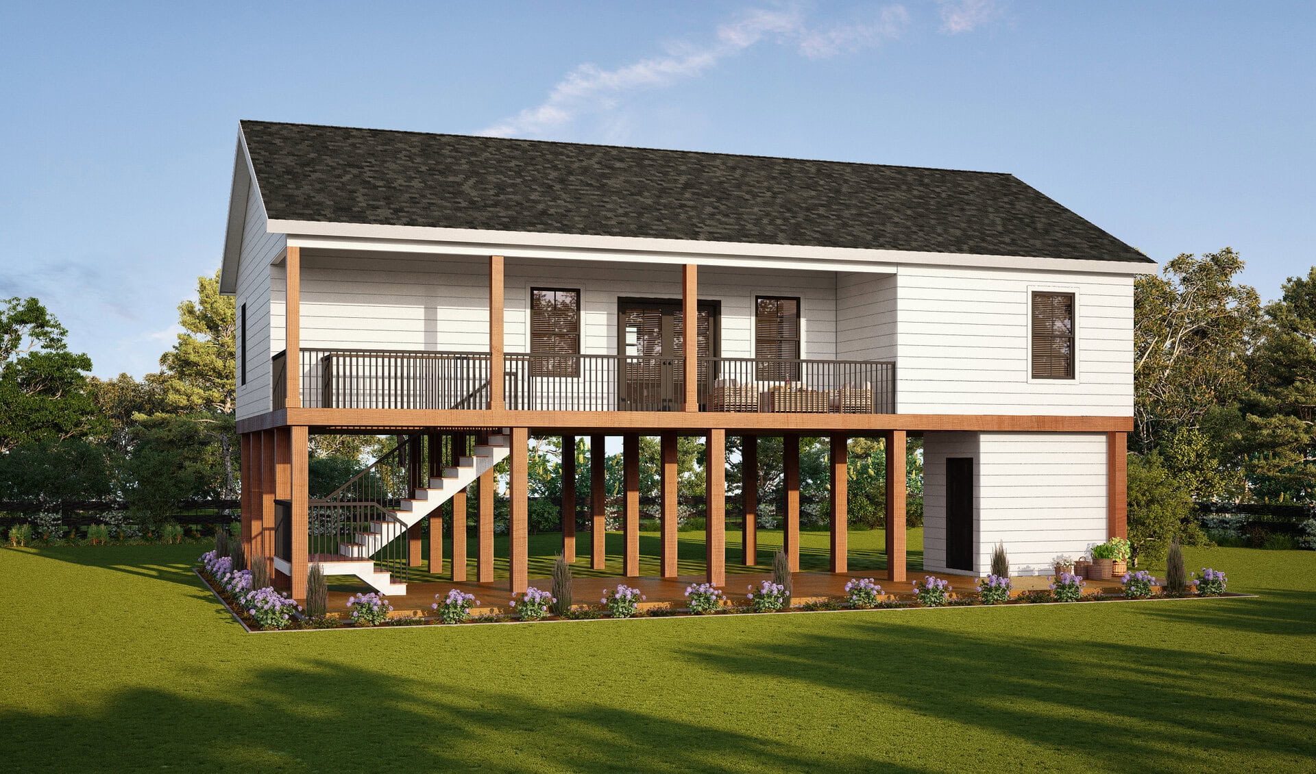 A white elevated house with a black roof sits on tall wooden stilts, featuring a wide front porch with railing, stairs leading up, and landscaped flower beds around the base. Lawn and trees surround the structure.